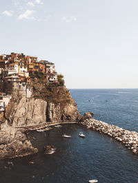 Scenic view of sea by buildings against sky