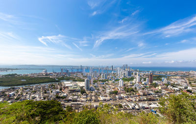 High angle view of buildings and sea against sky