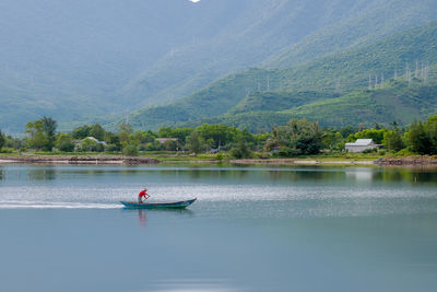 Person in boat on lake against mountain