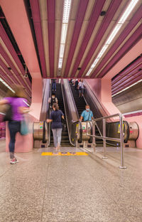 Blurred motion people moving in the pink train station in singapore