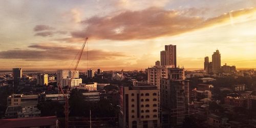 Buildings in city against cloudy sky