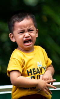 Portrait of crying boy sitting outdoors