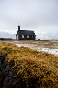 Black church of budhir with mountains covered in snow in the background