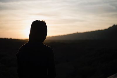 Rear view of silhouette man against sunset sky