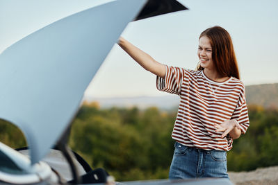 Rear view of young woman holding umbrella