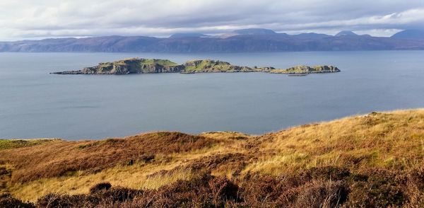 Scenic view of sea and mountains against sky