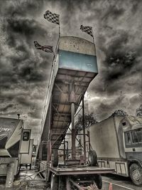 Low angle view of water tower against cloudy sky