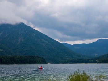 Scenic view of lake by mountains against sky