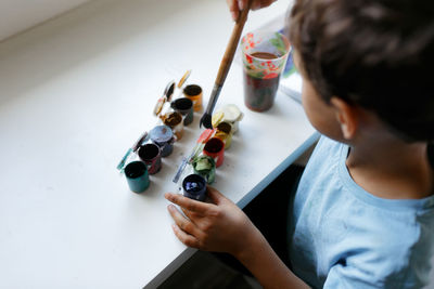 High angle view of boy painting at home