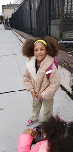 Portrait of smiling girl in standing on footpath 