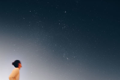 Low angle view of man standing against sky at night