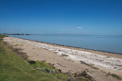 Scenic view of beach against blue sky