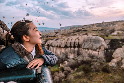 Side view of woman looking away on rock