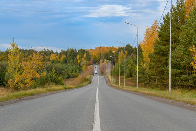 Road amidst trees against sky