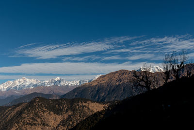 Scenic view of snowcapped mountains against blue sky