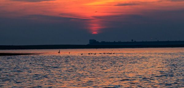 Scenic view of sea against orange sky