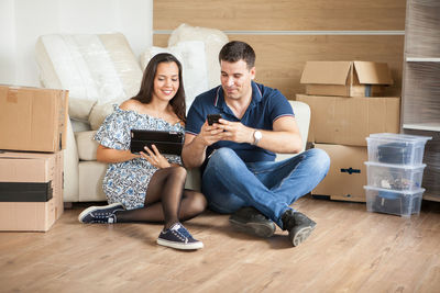 Young woman using laptop while sitting on sofa at home