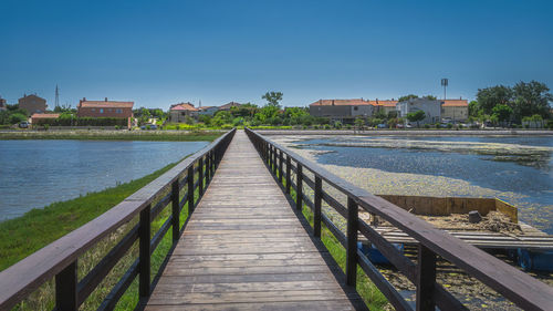 Footbridge over river against sky