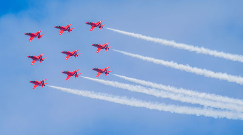 Low angle view of airplane flying against blue sky