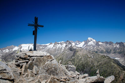 Cross on rock against blue sky