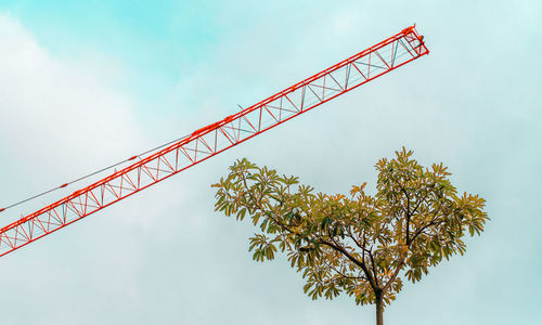 Low angle view of crane against sky