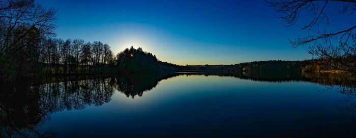 Scenic view of lake against clear blue sky