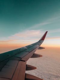 Airplane flying against sky during sunset