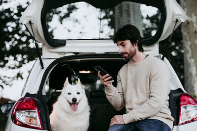 Rear view of man using smart phone