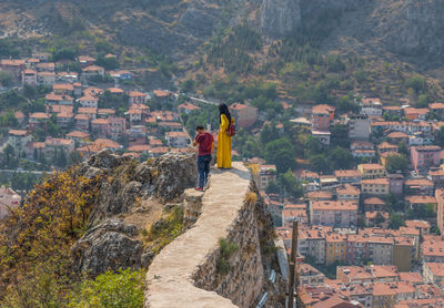 Rear view of woman standing on mountain against buildings