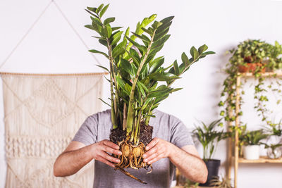 Midsection of man holding potted plant