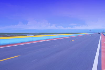 Blurred motion of road against blue sky