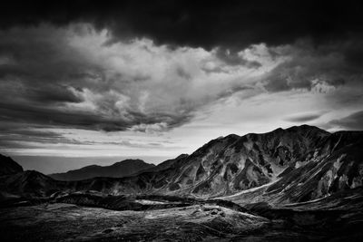 Idyllic view of mountains against cloudy sky