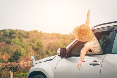 Woman in car against sky