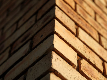 Low angle view of brick wall during sunny day