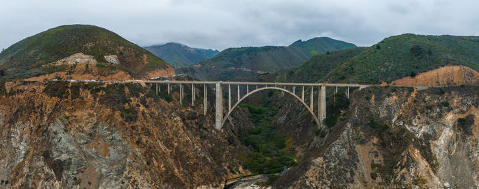 Bridge over mountains against sky