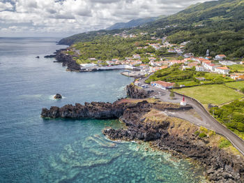 High angle view of sea by mountain against sky