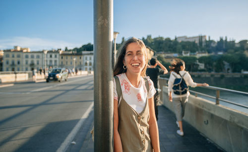 Portrait of smiling young woman standing in city