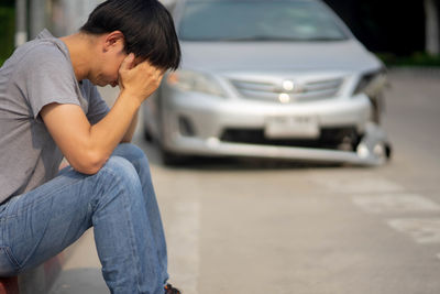 Side view of man sitting in car