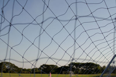 Close-up of fence on field against sky