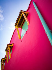 Low angle view of pink building against sky