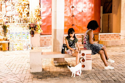 Women sitting on wall