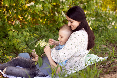 Cute boy with mom on a picnic. son hugs mom