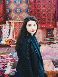 Portrait of beautiful young woman standing against wall