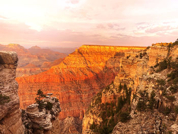 Rock formations on landscape against sky during sunset