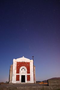 Building against clear blue sky at night