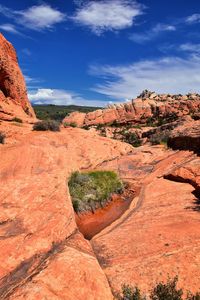 Rock formations on landscape against cloudy sky