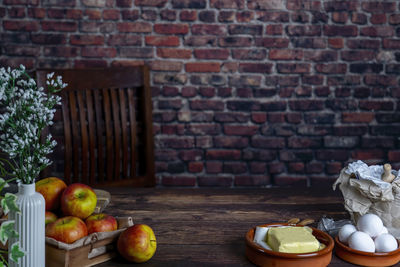 Apple on a wooden table as backdrop.background red brick wall.