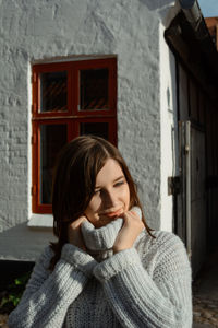 Portrait of smiling young woman against building