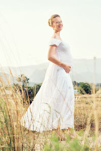 Portrait of woman standing on field against sky