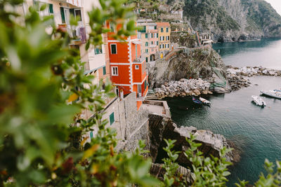 High angle view of houses by sea against trees